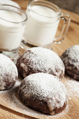 Fototapeta na wymiar Homemade chocolate cookies sprinkled with powdered sugar and mil