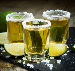 Gold Mexican tequila with lime and salt, selective focus