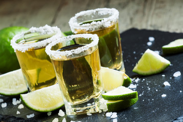 Gold Mexican tequila with lime and salt, selective focus