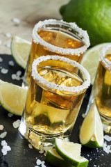 Gold Mexican tequila with lime and salt, selective focus