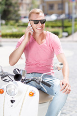 Fototapeta premium Handsome man doing selfie on scooter 