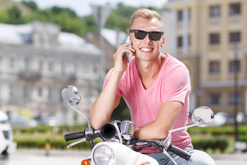 Fototapeta premium Handsome man doing selfie on scooter 