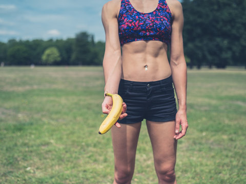 Fit woman offering banana