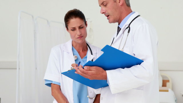 Two doctors looking at clipboard in medical office