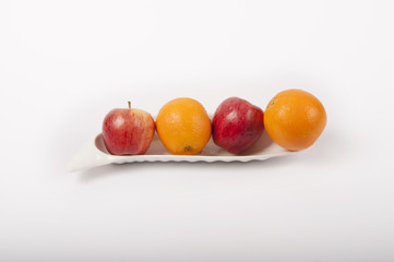 apple and orange fruits on plate like a boat with white background	