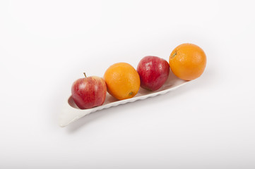apple and orange fruits on plate like a boat with white background	