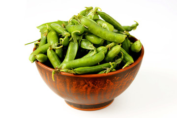 green peas in a clay bowl on a white background