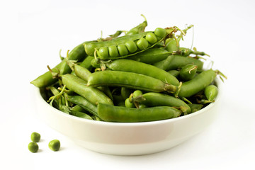 green peas in a white bowl on a white background