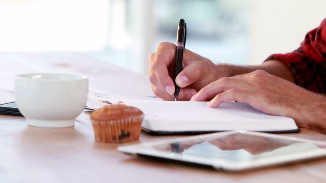 Hands of casual business man writing on paper 