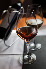 Closeup of two glasses and bottle of wine on the table