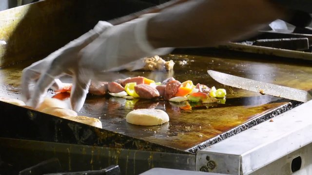 Chef removing buns from a grill
