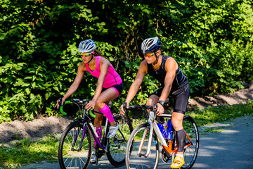 Obrazy na Plexi  Młoda para profesjonalnych rowerzystów jeżdżących po szosie