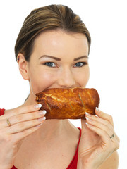 Attractive Young Woman Holding a Cooked Hot Savory Sausage Roll