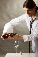 Man waiter pouring wine into glass.