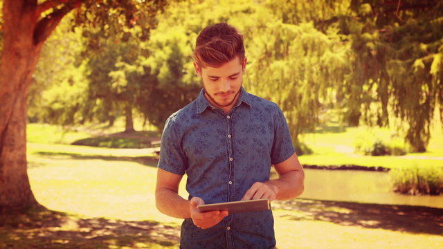 Handsome man using tablet in the park