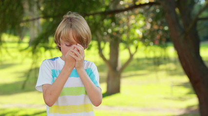 Little boy using his inhaler in the park