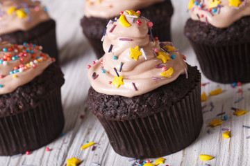 Fototapeta na wymiar Chocolate cupcakes decorated with cream close-up. Horizontal 