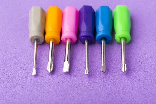 Mini colored screwdriver set on purple background
