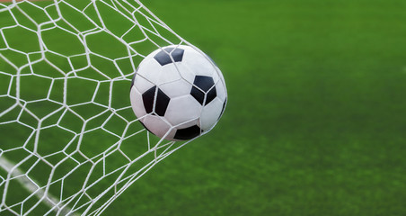 Fototapeta na wymiar soccer ball in goal with green backgroung