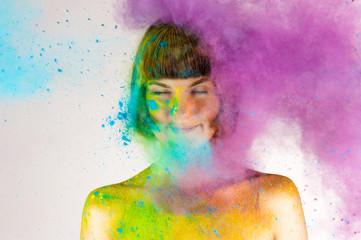 beautiful brunette girl in colors Holi on a white background