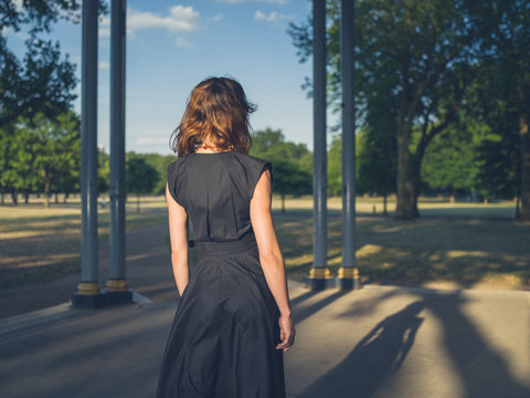 Elegant young woman in park at sunset