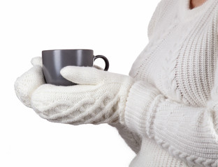 Fototapeta na wymiar Christmas concept. Coffee cup in female hands dressed in mittens