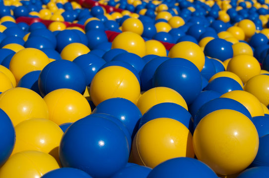 balles jaune et bleu dans une piscine pour enfants