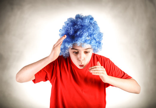 ragazzino con parrucca azzurra che fa il buffone