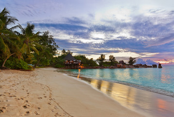 Fototapeta na wymiar Cafe on Seychelles tropical beach at sunset