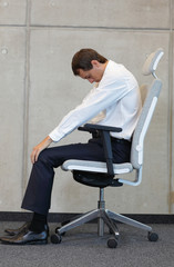 yoga with chair in office - business man exercising 