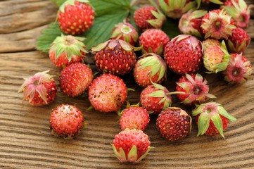 Wild strawberries Fragaria viridis on wooden background