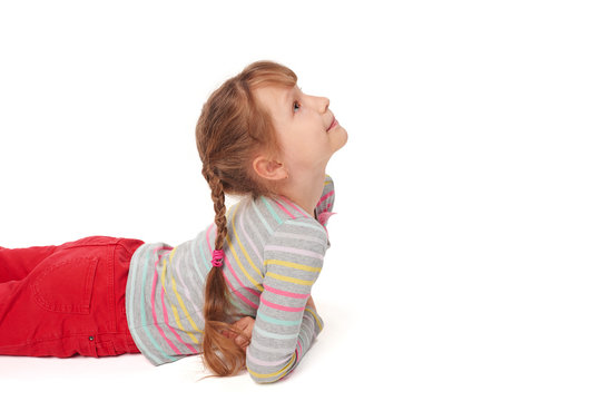 Side view of smiling child girl lying on the floor