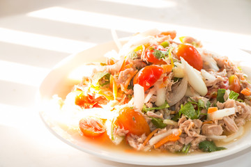 Spicy Tuna Salad onion and tomatoes in plate put on wooden background , Thailand cuisine.