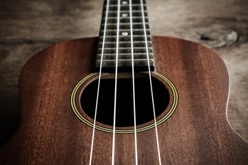 Close up of ukulele on old wood background