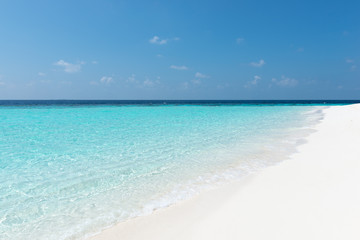 Tropical turquoise lagoon in  Indian Ocean. Bright blue sky with clouds. Used a polarizing filter