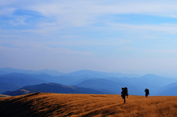 two backpackers hiking in mountains