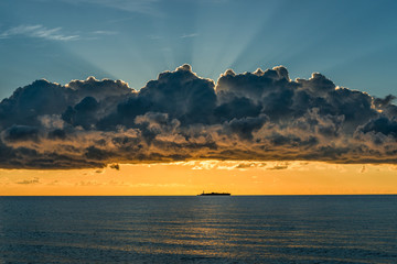 The sun comes out behind the clouds. 