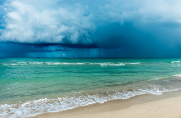 Storm over the ocean. Over the ocean storm with heavy clouds, dramatic sky. White sand of  Miami  beach.