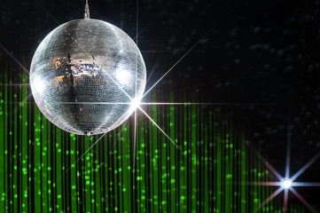 Disco ball with stars in nightclub with striped green and black walls lit by spotlight