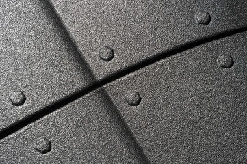 Surface of powerful suv bodywork, side part of car with bolts and black textured paint coating,...