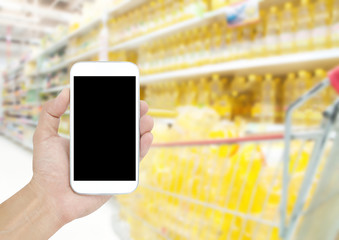 Hand holding mobile on Supermarket blur background , concept