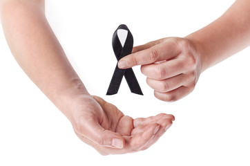 Black ribbon held in female hands on white background