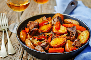 Meat roasted with potatoes, carrots, onions, rosemary and garlic