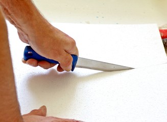 Handwerker schneidet Isolierung