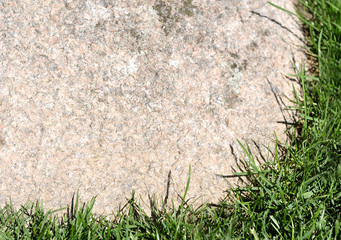 Textured background natural stone frame with grass