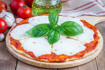 Homemade pizza with mozzarella cheese on a wooden board