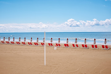 A beach with umbrellas and sun beds on coast of Terracina, Italy