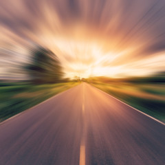 vintage photo of country asphalt road in motion blur at sunset.