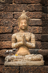 Stone buddha statue seated in prayer pose at Wat Jet Yod, Chiang Mai, Thailand
