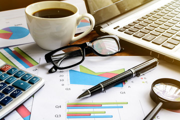 Laptop on Desk office and Graph analysis spreadsheet, Business f